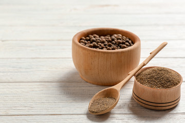 Composition with powdered pepper and corns in wooden dishware on table