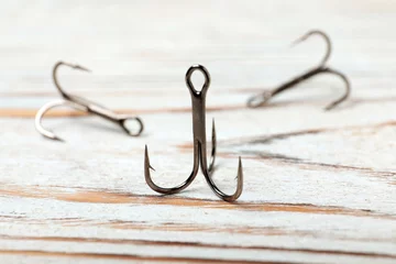 Draagtas Fishing hooks on wooden table. Angling equipment © New Africa