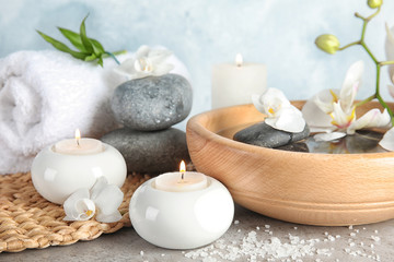 Composition with spa stones and candles on gray table