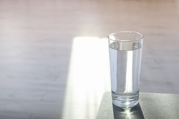 Glass of pure water on table indoors. Space for text