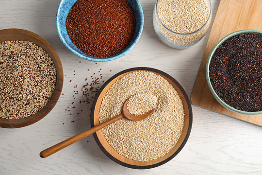 Flat lay composition with different types of quinoa on white wooden background