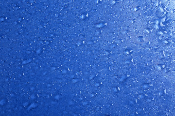 Water drops on color background, top view