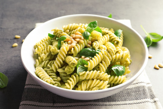 Fototapeta Plate with delicious basil pesto pasta on gray table