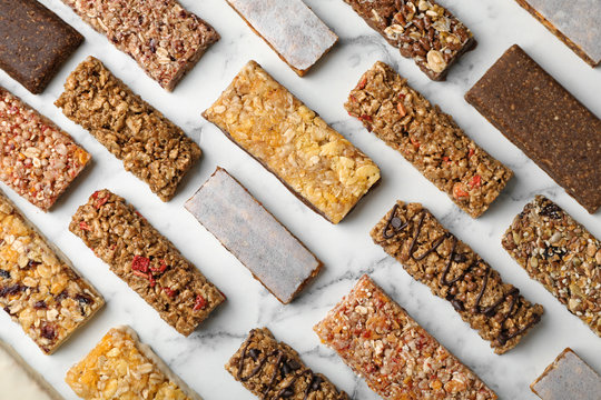 Flat lay composition with protein bars on marble background