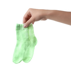 Woman holding pair of cute child socks on white background, closeup