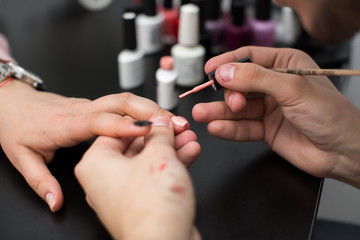 Closeup shot man making manicure to woman in beauty salon