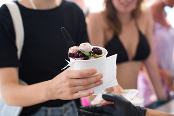 Stir-fried ice cream rolls at freeze pan. Rolled ice cream, hand made ice cream dessert. Fried ice cream machine with steel chilled pan.