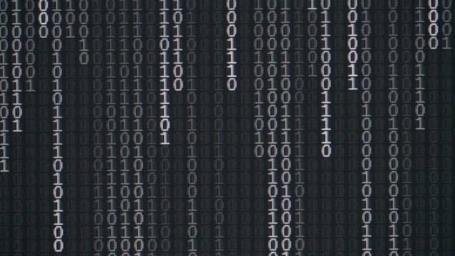 Abstract binary computer code flowing on a screen.