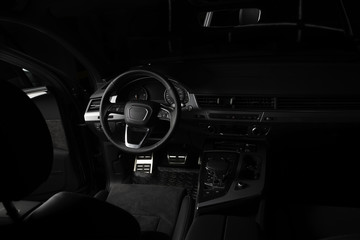 Interior of luxury suv car with black leather steering wheel and shift gear. Alcantara cockpit...