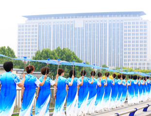 Women in cheongsam are walking，on the bridge