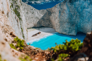 Famous shipwreck on Navagio beach with turquoise blue sea water surrounded by huge white cliffs. Famous landmark location on Zakynthos island, Greece. Nature framed