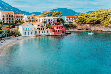 Assos village. Beautiful view to vivid colorful houses near blue turquoise colored transparent bay lagoon. Kefalonia, Greece