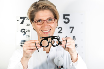 Young eye doctor W34 with testing frame on the eye chart, Germany, Europe