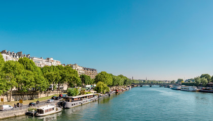 Fototapeta na wymiar Manned barges moored to the coast of Seine river in Paris