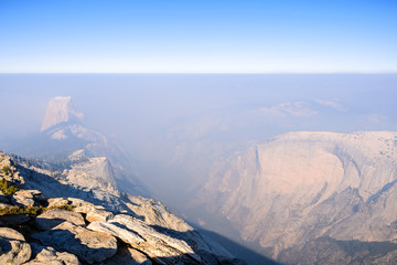 View towards Half Dome and the valley beyond on a day with low visibility due to the smoke coming from the Ferguson Fire, Yosemite National Park, California