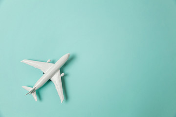 Simply flat lay design miniature toy model plane on blue pastel colorful paper trendy background. Travel by plane vacation summer weekend sea adventure trip journey ticket tour concept