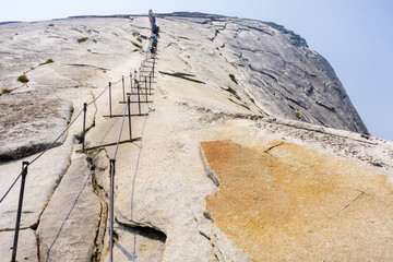 Going up on the Half Dome cables on a summer day  smoke visible in the air from Ferguson Fire  Yosemite National Park, California