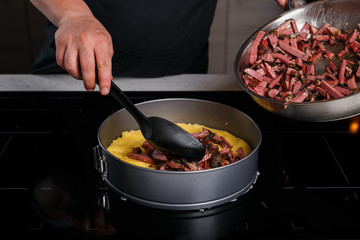 Chef puting fried lamb jerkey on polenta