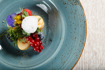 Fried pears on a bed of ground pistachios, garnished with egg mousse