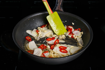 Frying pan with onions and red chilli
