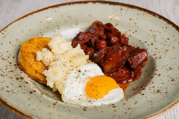 Romanian traditional food, polenta with fried egg and spicy meat
