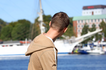 the teenager looks at the sailboat