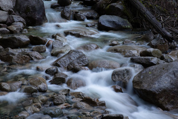 Fototapeta na wymiar Long exposure of river water flowing over rocks in british columbia, canada