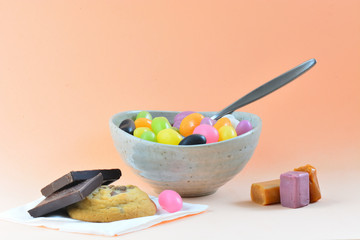 A close-up photo of a meal consisting of some colorful jelly beans, mixed sweets and cookies. Concept of unhealthy diet