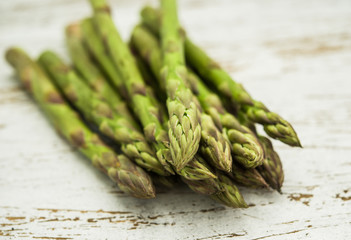 Close up of a bunch of asparagus against white wooden background. Concept of cooking and eating healthy food, fitness, dieting, vegetarian food, vegan cuisine and healthy lifestyle. 