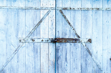 old Board gate of the barn shackled with iron and covered with peeling paint-background image