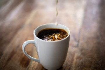 Cup of Coffee with Cream Pouring