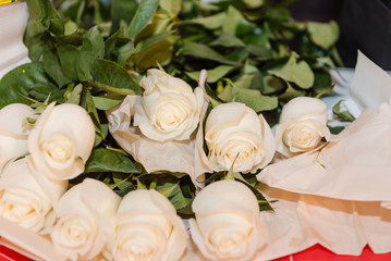 White roses lie on a bright table. Beautiful white flowers.