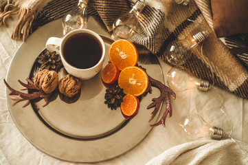 Christmas still life with cup with tea or coffee, cookies in the shape of snowflakes, oranges with christmas decorations and nuts