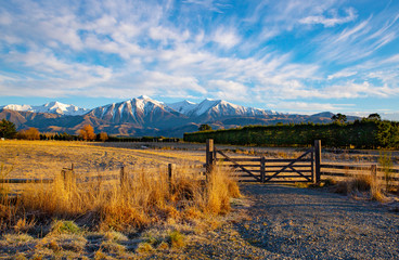 The sunrises over the frosty farmland warming up the picturesque landscape and wooden farm gate