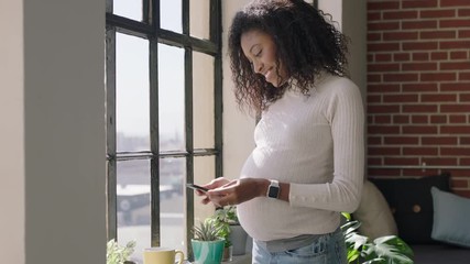 happy pregnant african american woman using smartphone sharing maternity lifestyle on social media smiling enjoying mobile phone communication browsing messages drinking coffee in apartment home - Powered by Adobe