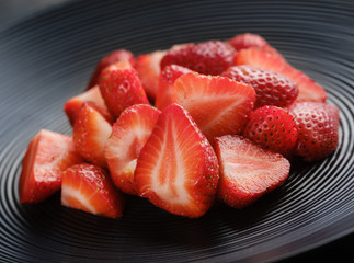 juicy strawberries on a black plate