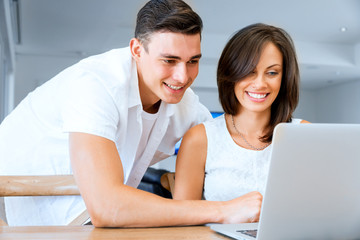 Obraz premium Happy modern couple working on laptop at home