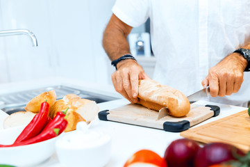 Male hands cutting bread