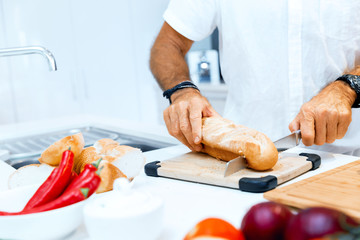 Male hands cutting bread