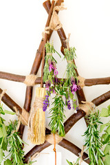 Witch's Broom / Besom hanging on rustic branch pentagram herb dryer with fresh herbs