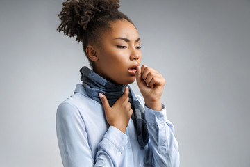 Sick woman with sore throat. Photo of african american woman in blue shirt suffering virus of flu...