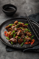 sweet sticky pork served with chives and  sesame seeds