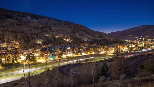 Light trails on highway passing town of Vail, Colorado at night