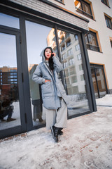fashion outdoor photo of gorgeous sensual woman with black hair in elegant clothes  walking by winter city