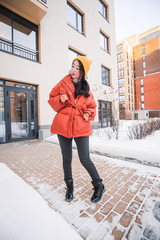 fashion outdoor photo of gorgeous sensual woman with black hair in elegant clothes  walking by winter city