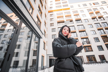 fashion outdoor photo of gorgeous sensual woman with black hair in elegant clothes  walking by winter city