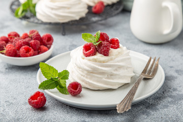 mini pavlova  meringue cakes with whipped cream and fresh raspberry