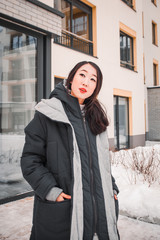 fashion outdoor photo of gorgeous sensual woman with black hair in elegant clothes  walking by winter city