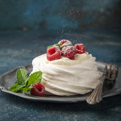 mini pavlova  meringue cake with whipped cream and fresh raspberry