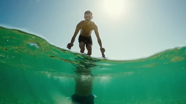 Young teen fall in water from standing to his father shoulders, gopro dome half underwater view, SLOW MOTION